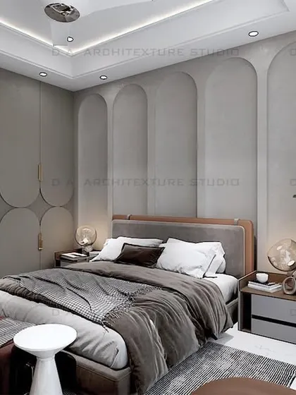 This bedroom design in Naraina uses arched panels and circular motifs on the wardrobe to create a soft, elegant aesthetic. The grey and brown color scheme is both modern and warm.