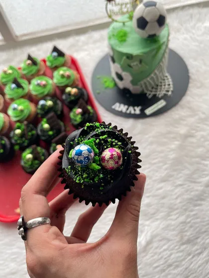 A matching cupcake from the football-themed party set. I used chocolate frosting with green sprinkles to look like a grassy field and topped it with tiny edible soccer balls.