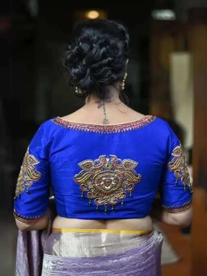 The back of this royal blue blouse is heavily embroidered with a traditional Zardosi motif, making it a truly regal piece.