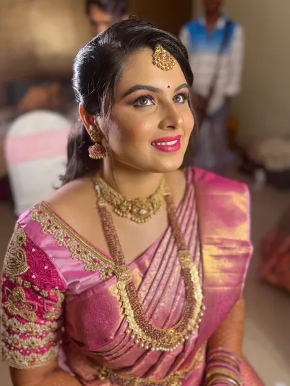 A radiant smile from a happy bride. This upward-looking shot captures the joy of the moment, highlighting the clean, defined eye makeup and the perfect shade of pink lipstick.