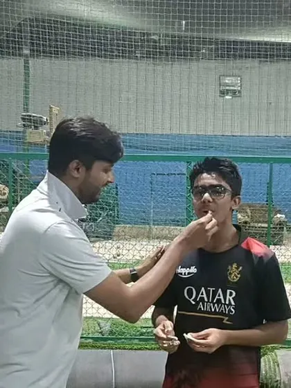 Another teammate joins in the birthday celebration. The bonds formed here go beyond the cricket field.