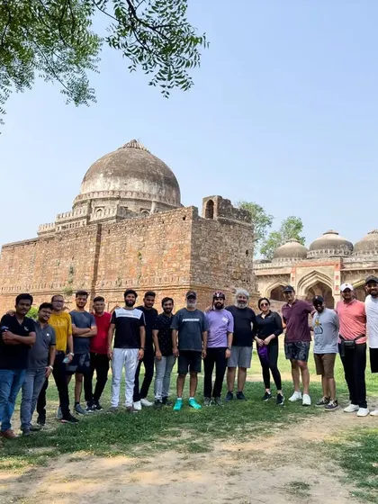 Our group stands before a magnificent tomb in Lodhi Garden. This park is a treasure trove of 15th-century architecture and a key part of our South Delhi tours.