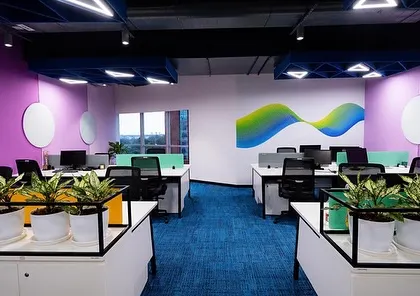 A section of the colorful and vibrant Tata Consumer Products office. The clean white planters and green foliage provide a natural counterpoint to the bright brand colors, creating a balanced and energetic workspace.