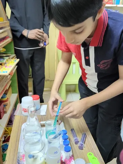 A student carefully measures a substance with a syringe during our "Serious Study on Proteins" session.