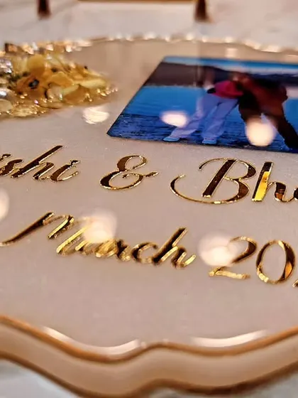 A simple and sweet photo frame made with love. This piece features the couple's names and wedding date on a white resin base with a gold edge and floral accent.