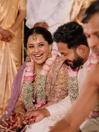 A candid moment of laughter between the bride and groom during their Bunt wedding ceremony.