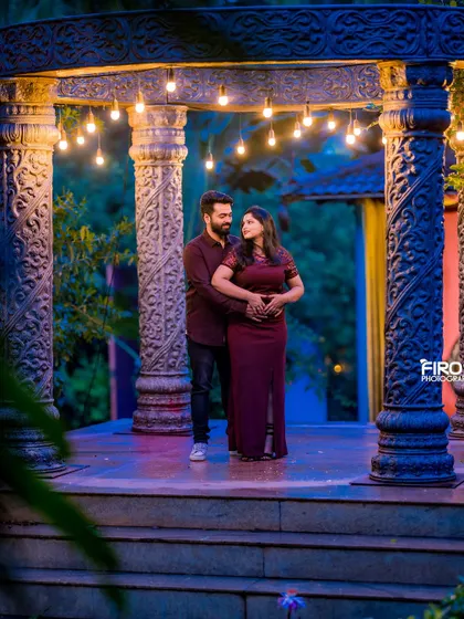 A romantic embrace under the stone archway, lit by hanging bulbs. The moody lighting and the couple's close pose create a deeply intimate and cinematic feel.
