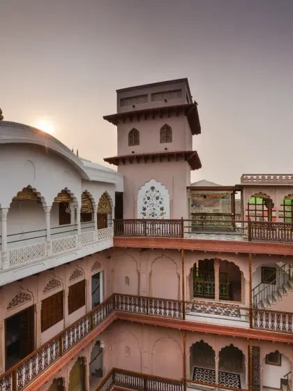 The massive jharoka on the third level is a striking feature, incorporating both Rajasthani and Jain architectural styles. The railings feature intricate laser-cut stone motifs, showcasing our commitment to detailed craftsmanship.