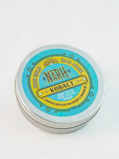 A simple, clean shot of a tin of hair styling pomade. The high-angle view clearly shows the branding and lid design, perfect for a catalogue.