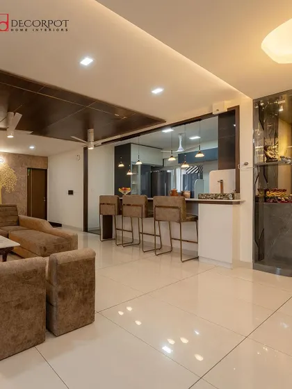This open-plan living and dining area features a kitchen with a breakfast bar. The pendant lights above the counter add a stylish touch and define the space.
