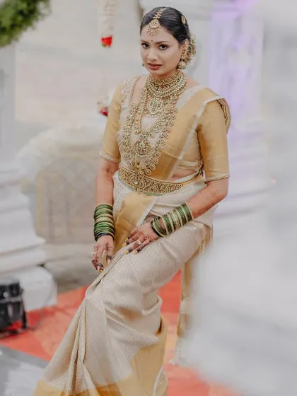 A vision in a white and gold Kanjeevaram saree, this bride's look is a perfect example of classic South Indian elegance.