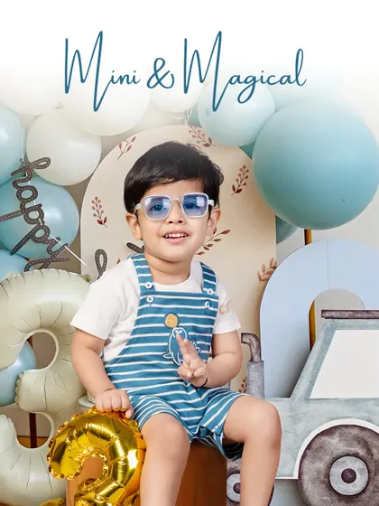 Mini and magical, this little boy celebrates his third birthday with a cool, blue-themed setup complete with balloons and a stylish car prop. His fun sunglasses add the perfect touch of personality.