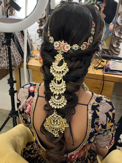 A close up of this trendy messy braid with stunning accessories. This is a great option for a Mehendi or Sangeet event, combining traditional elements with a modern twist.