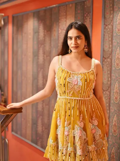 Let the details do the talking. This short yellow dress with floral and pearl embellishments is a charming and playful choice for a day event.