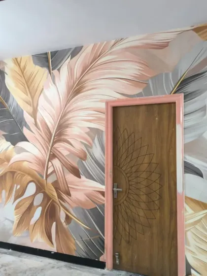 A large-scale tropical leaf mural with soft pastel tones. This custom design adds a modern, artistic touch to the room, and I made sure to wrap it seamlessly around the door frame.