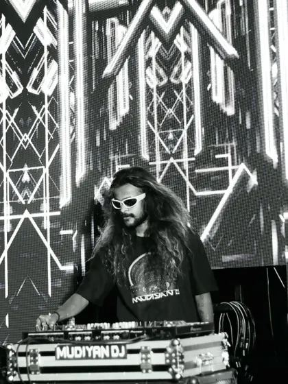 A stylish black and white photo of me at the decks, with a complex geometric pattern on the LED screen behind me.