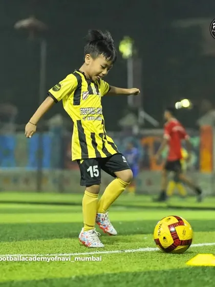A young player practices his dribbling with a bright yellow ball, adding a fun element to our training sessions.