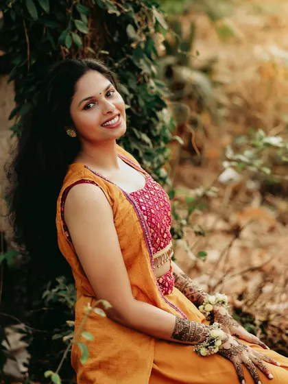 A sun-kissed portrait of a bride during her Haldi ceremony, her smile warm and genuine.