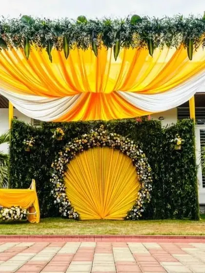 This vibrant outdoor naming ceremony setup shows my ability to transform open spaces. The bright yellow fabric and circular floral backdrop create a cheerful and grand setting for the celebration.