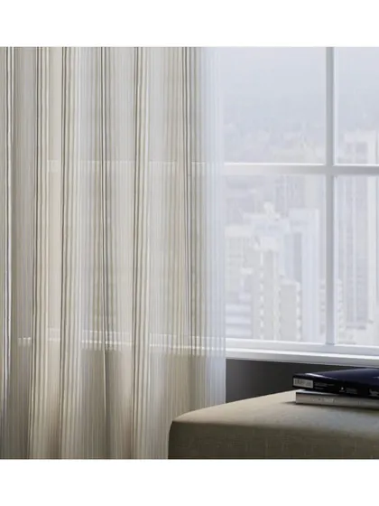 Sheers can create a luxe and ethereal atmosphere. The 'Oakland' fabric, with its subtle vertical stripes, adds height and a soft, filtered light to this room, enhancing its modern and airy feel.