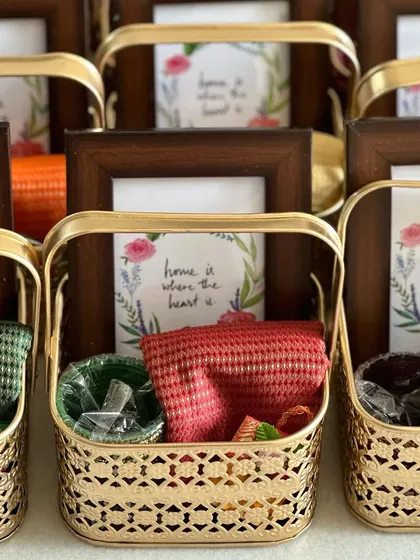 A detailed look at the contents of our housewarming favor baskets, which include a blouse piece, bangles, and a personalized photo frame.