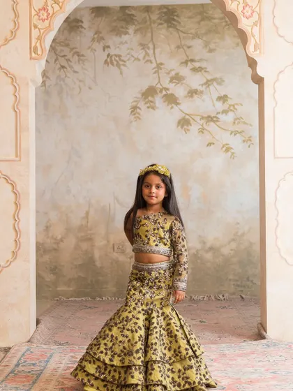 This unique printed lehenga in a chartreuse yellow offers a contemporary twist on traditional wear, with a one shoulder top.