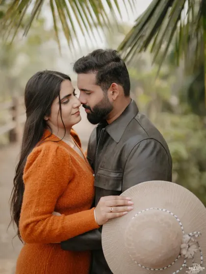 A beautiful, soft-focus portrait of the couple about to kiss, using a prop hat to add a touch of rustic charm.