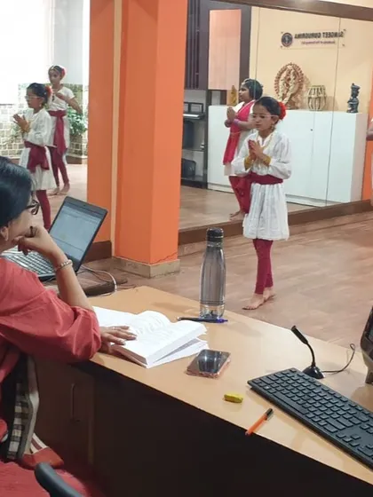 Young Bharatanatyam students presenting their practical exam online, demonstrating their skills for the examiners on screen.