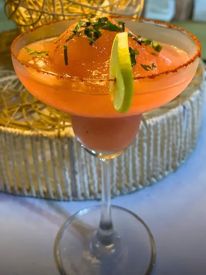 A close-up of the Peru-Paprika mocktail, showcasing its icy texture and lime garnish. It's the perfect balance of sweet, tangy, and spicy.