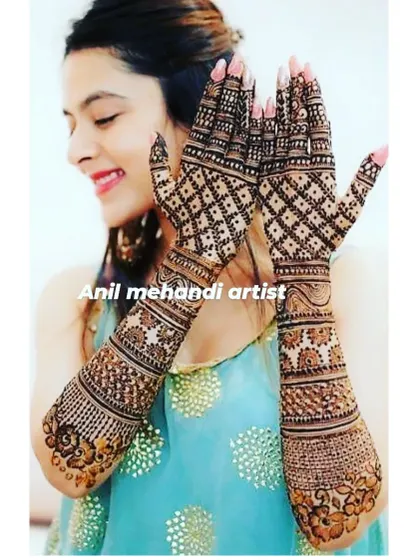 This bride is striking a pose with her gorgeous geometric and floral mehendi. The design covers her arms fully, creating a very elegant and complete bridal look.