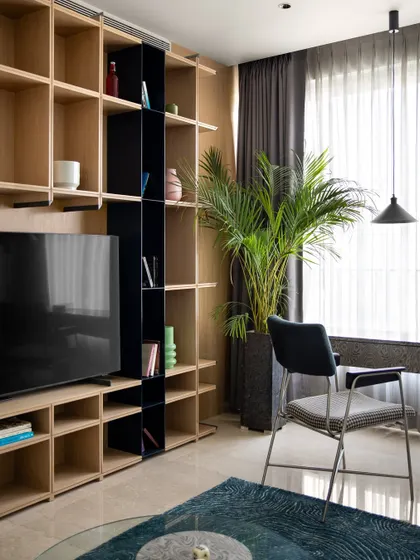 The full view of the media and shelving wall in the multipurpose room. The design provides ample storage and display space while maintaining a clean, uncluttered aesthetic.