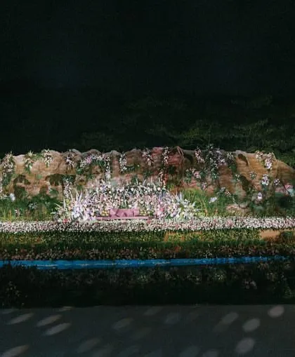 A frontal view of the reception stage, highlighting the gigantic fountain, the intricate floral landscape, and the two unique dome-like structures we created for entry and exit.