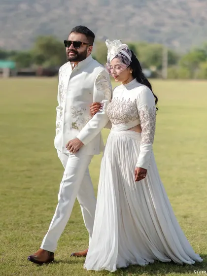A sophisticated portrait of a couple dressed in all white for a polo match event in Jaipur. The image exudes a vintage, royal elegance, perfectly suited for a heritage location.