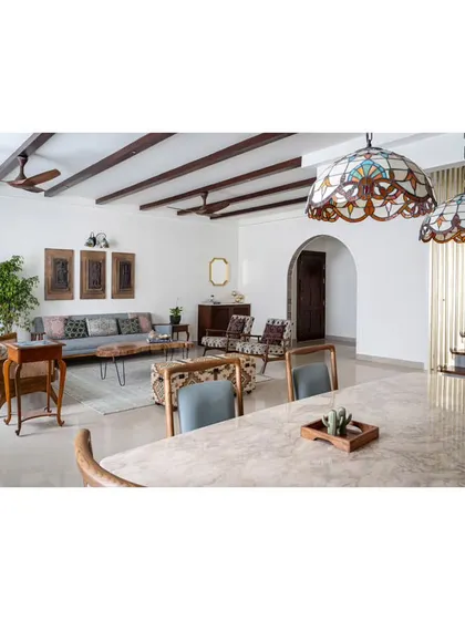 The open-plan living and dining area, unified by walnut-hued wooden rafters on the ceiling. This architectural element adds a vintage allure and conceals electrical wiring for a clean look.