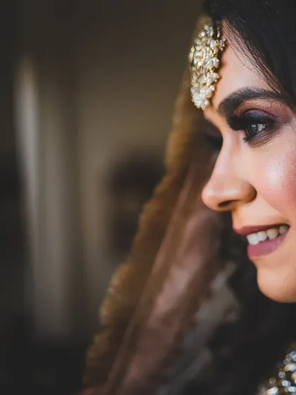 A candid profile of the bride, Simrita, her smile captured in a quiet moment.