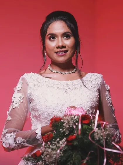 A beautiful bride holding her bouquet at her Christian wedding. Her makeup is soft and romantic, with a focus on her eyes.