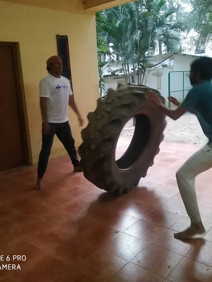 Two students work together on a tire flip drill, a staple of our strength and conditioning program.