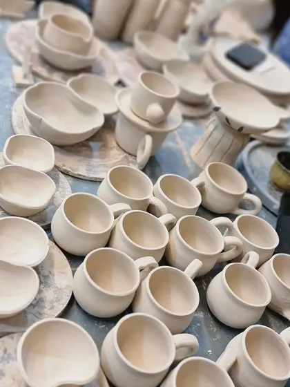 A random shot from the studio, showing dozens of mugs and bowls in their pre-fired 'greenware' state. This is just one stage in the long journey each piece takes before it's finished.