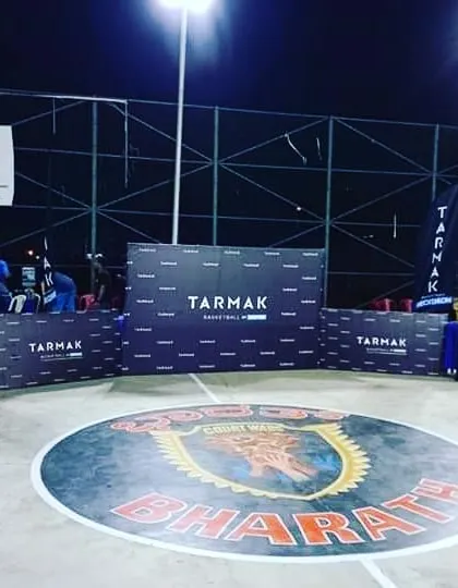 A duplicate shot of the branded basketball court setup at night.