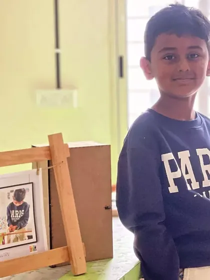 This student proudly displays his finished photo frame, ready to hold a favorite memory.