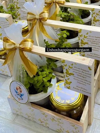 Announce the arrival of your little one with these elegant favors. This "It's a girl" announcement basket features a lucky jade plant and a jar of sweet treats, complete with a personalized card, making it a thoughtful and sustainable gift for loved ones.