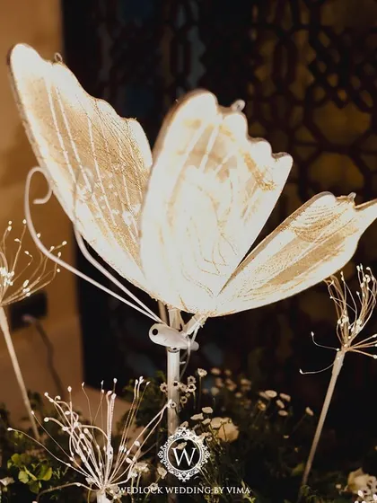 An enchanted forest Sangeet night, where the ceiling was a canopy of lush greenery dotted with sparkling disco balls and glowing LED butterflies. This immersive decor created a magical atmosphere for dancing.