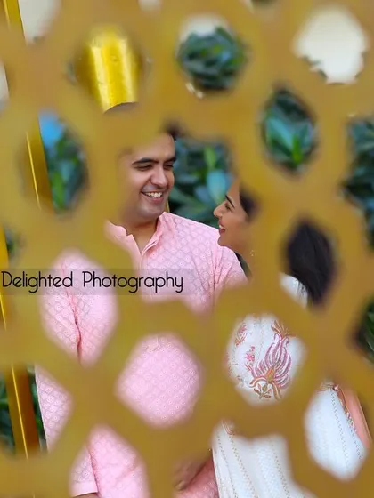 A creative shot of the couple seen through a decorative screen. This framing adds depth and a sense of a stolen, private moment.