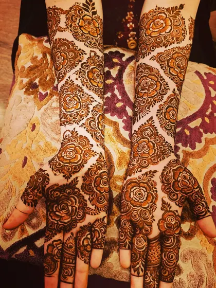 A stunning designer mehndi with a diamond-shaped rose trellis pattern. This is a very modern and elegant look.