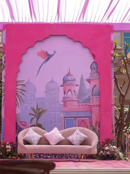 Another seating area with a custom-printed backdrop depicting a whimsical palace scene. The blush-colored sofa and soft cushions provided a perfect spot for photos.