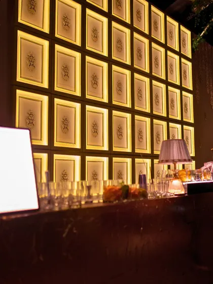 The backlit bar at the Indo-chic Sangeet, featuring a wall of framed traditional motifs.