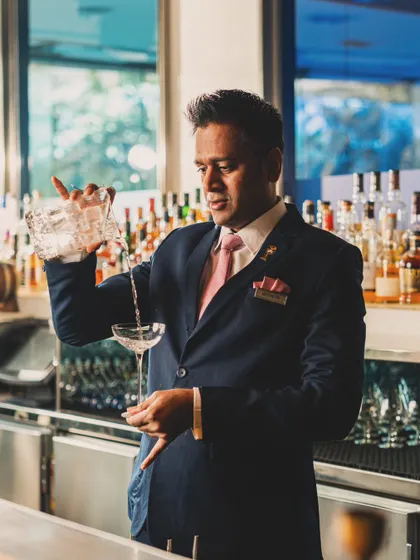A portrait of a bartender in action, pouring a classic cocktail. Capturing the human element behind the bar adds authenticity and tells the story of the establishment.