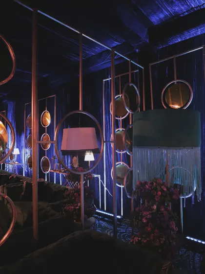 The moody lighting in the Sangeet lounge, with deep blues and purples creating a sophisticated and relaxed atmosphere.