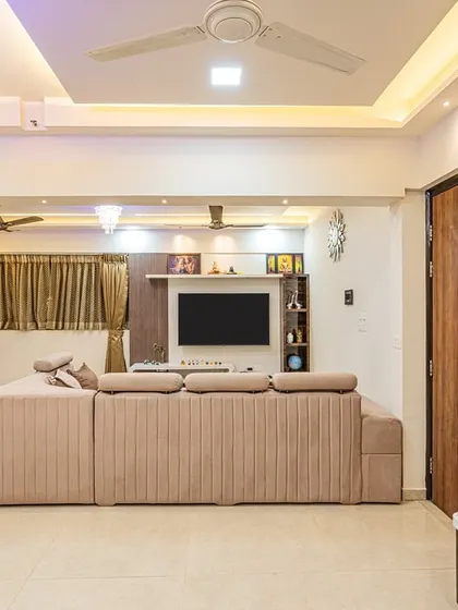 A wide shot of this spacious living room, showing how the large sofa, TV unit, and indoor swing all fit together without feeling crowded. This is the result of careful space planning.