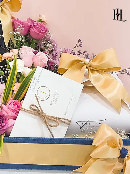 Detail shot of the birthday hamper, focusing on the "Wellness Circle" spa voucher and other elegantly wrapped gifts. It shows my commitment to including high-quality, thoughtful items that go beyond the usual.
